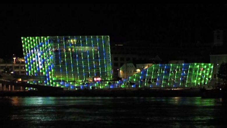Ars Electronica Center, its facade lights up in green and blue colors.